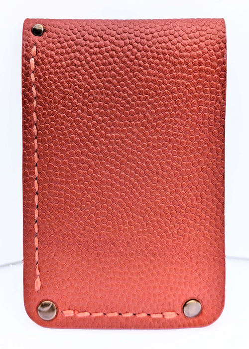 A textured leather card holder or wallet in a warm red-orange color, featuring a pebbled leather finish, decorative contrast stitching, and metal rivets buttons at the corners.